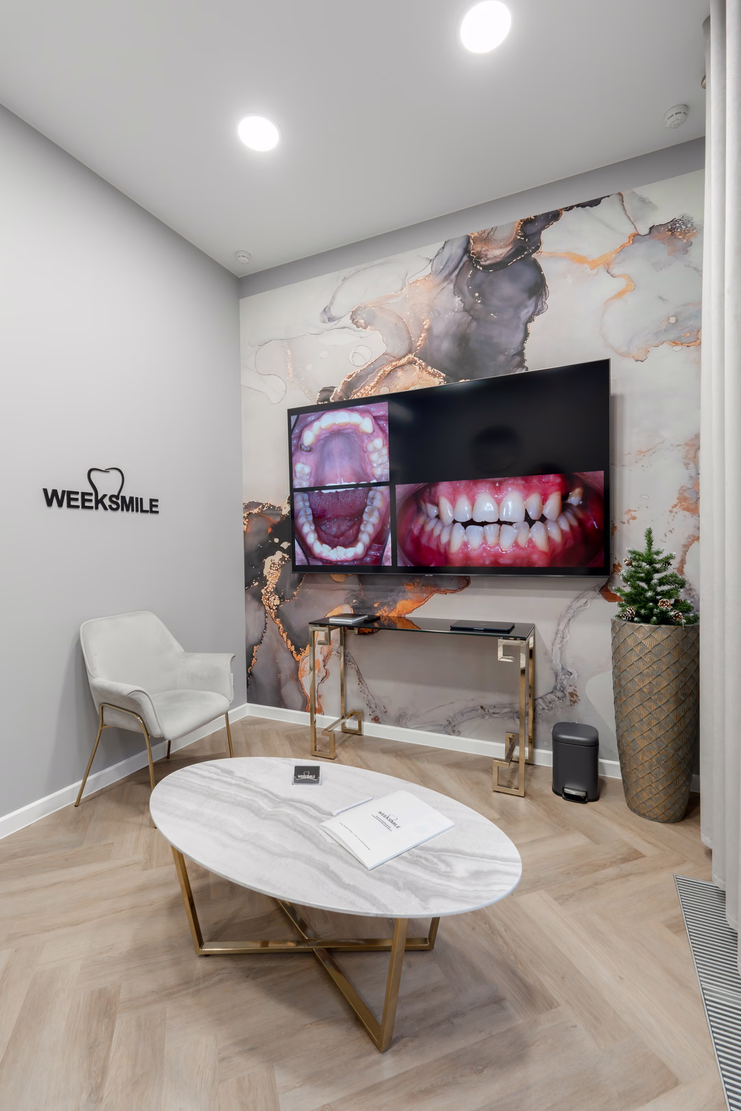Зона ожидания Weeksmile с большим экраном, креслом и овальным журнальным столом