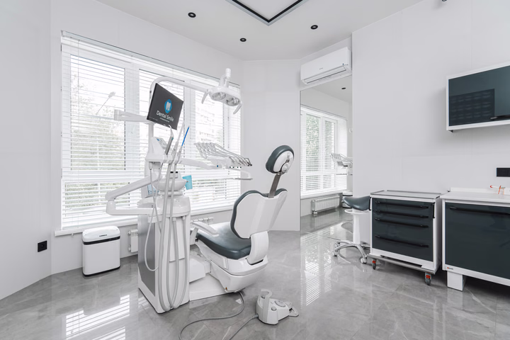 Стоматологическая установка Dental Smile у окна, вид сбоку на кресло и рабочие тумбы
