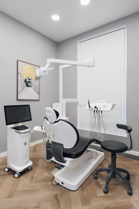 Стоматологический кабинет Weeksmile с чёрным креслом, монитором и окном с жалюзи