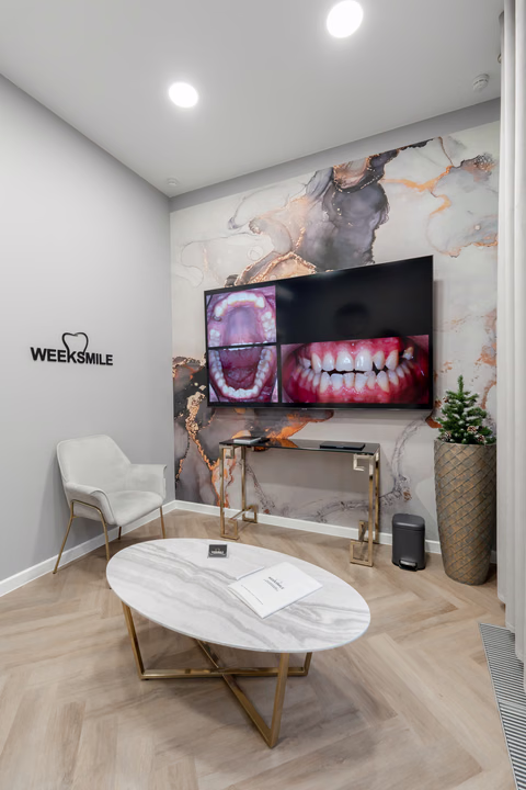 Зона ожидания Weeksmile с большим экраном, креслом и овальным журнальным столом