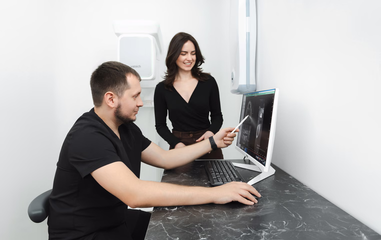 Сотрудник Weeksmile за компьютером показывает снимок стоящей рядом женщине